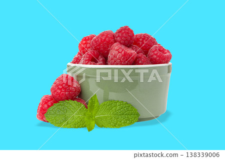 Red raspberries in a bowl with green mint leaves nearby Red raspberries in a bowl with green mint leaves nearby 138339006