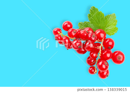 Red currants with green leaves on blue surface Red currants with green leaves on blue surface 138339015