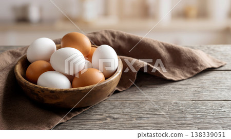 Fresh White and Brown Chicken Eggs in a Rustic Wooden Bowl on Table 138339051