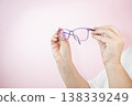 Woman hand holding eyeglasses on light background, Transparent eyeglasses 138339249
