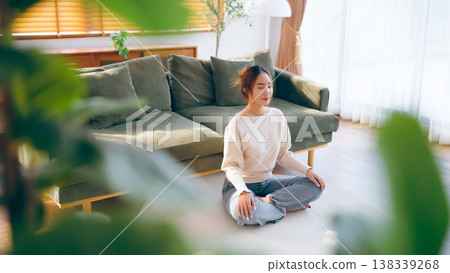 Happy young Asian woman practicing yoga and meditation at home Happy young Asian woman practicing yoga and meditation at home 138339268