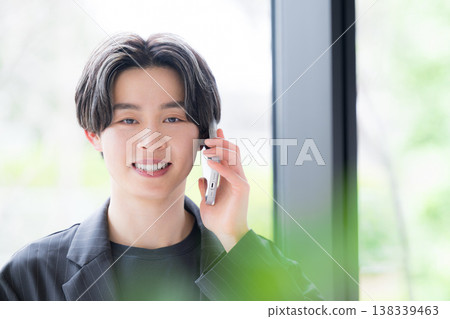 一位年輕男性商務人士正在接聽電話,展現出值得信賴的客戶服務能力,包括銷售、溝通和諮詢。 一位年輕男性商務人士正在接聽電話,展現出值得信賴的客戶服務能力,包括銷售、溝通和諮詢。 138339463