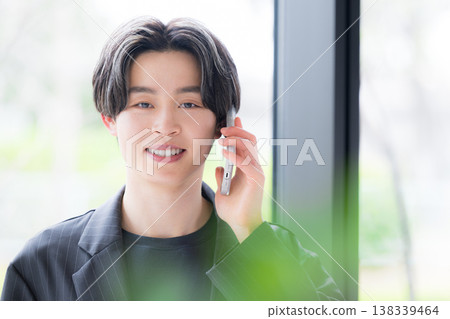 The upper body of a young male businessman handling phone calls, conveying a sense of trustworthiness in customer service, including sales, communication, and consultation. The upper body of a young male businessman handling phone calls, conveying a sense of trustworthiness in customer service, including sales, communication, and consultation. 138339464