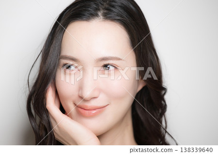 一張年輕女子擁有美麗黑髮的唯美照片,背景是白色;這張照片讓人聯想到觸摸肌膚的感覺,例如護膚品。 一張年輕女子擁有美麗黑髮的唯美照片,背景是白色;這張照片讓人聯想到觸摸肌膚的感覺,例如護膚品。 138339640