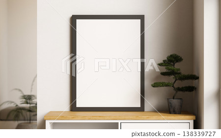Empty black photo frame and bonsai tree pot on wooden table aside white wall in a living room corner Empty black photo frame and bonsai tree pot on wooden table aside white wall in a living room corner 138339727