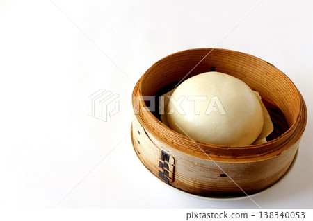 Chinese steamed buns in a steamer basket against a white background 138340053