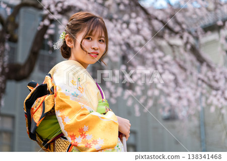 身穿和服的20歲女子，背景是盛開的櫻花。 138341468