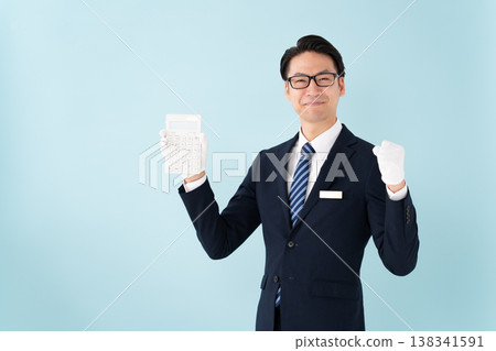 一名戴著白手套、手持計算器的男子揮拳慶祝。 一名戴著白手套、手持計算器的男子揮拳慶祝。 138341591