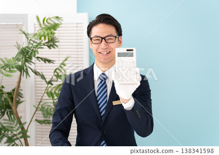 Man wearing white gloves holding a calculator 138341598