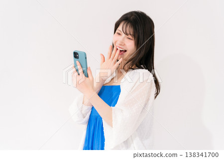 一位拿著智慧型手機的女士感到驚訝。 138341700