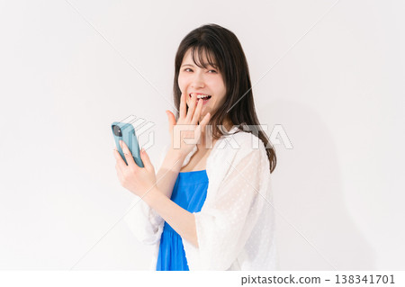 一位拿著智慧型手機的女士感到驚訝。 138341701