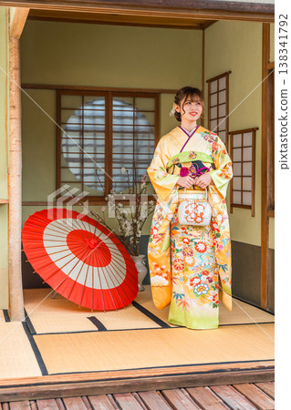 一位身穿振袖和服的日本年輕女子在日式房間(成年禮、20歲生日慶祝活動) 一位身穿振袖和服的日本年輕女子在日式房間(成年禮、20歲生日慶祝活動) 138341792