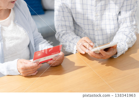 Senior couple calculating using their bankbook. 138341963