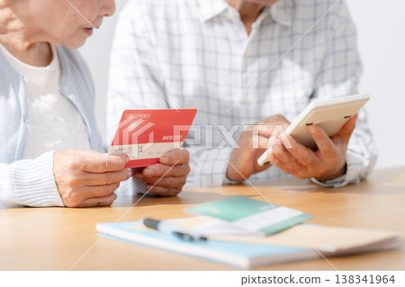 Senior couple calculating using their bankbook. 138341964