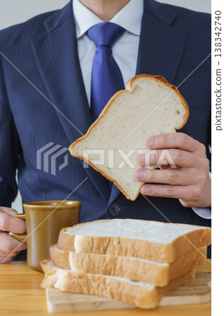 A man in a suit holding a slice of bread A man in a suit holding a slice of bread 138342740