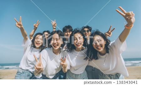 A group photo of a group of East Asians laughing on the beach. 138343041