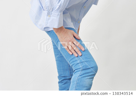 一位女士在白色背景下抱著她的大腿 138343514