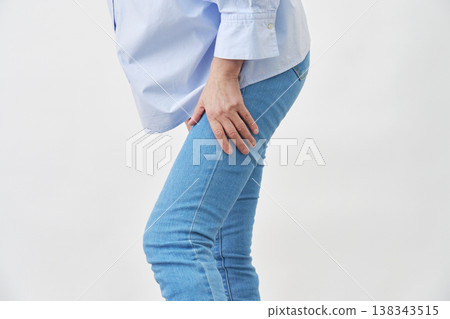 一位女士在白色背景下抱著她的大腿 138343515
