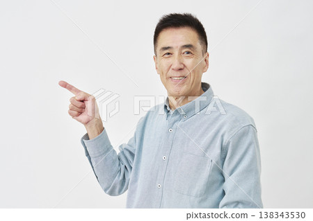 一名男子在白色背景前指向左側。 138343530