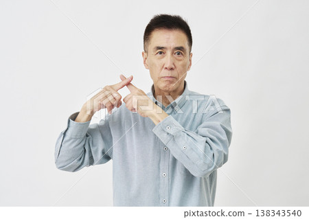 A man making an "X" gesture against a white background. A man making an "X" gesture against a white background. 138343540