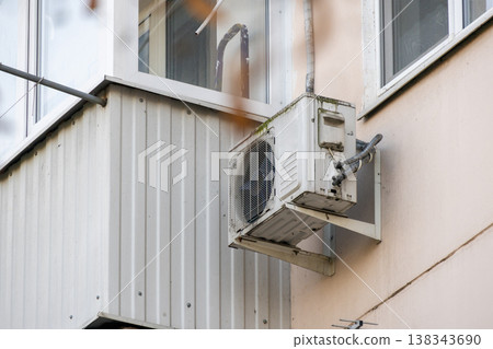 air conditioner is installed on facade of the building. air conditioner compressor is on wall. air conditioner is installed on facade of the building. air conditioner compressor is on wall. 138343690