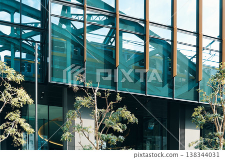 A railway bridge and train reflected in the city's buildings. 138344031