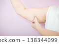 Caucasian overweight woman pinching arm fat while flexing muscle 138344099