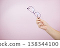 Woman hand holding eyeglasses on light background, Transparent eyeglasses 138344100