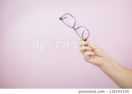 Woman hand holding eyeglasses on light background, Transparent eyeglasses 138344100