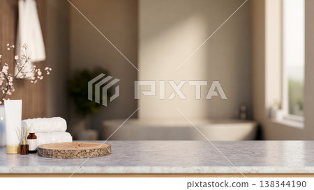 Skincare and diffuser aside tree stump tray and towel on marble counter across tub in dim bathroom. Skincare and diffuser aside tree stump tray and towel on marble counter across tub in dim bathroom. 138344190