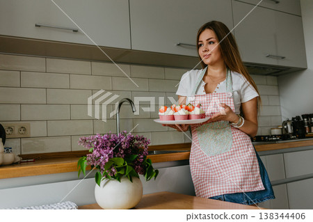 Woman preparing tasty Easter cupcake in kitchen 138344406