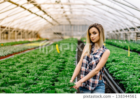 Young woman buying flowers at a garden center color toned image shallow DOF. 138344561