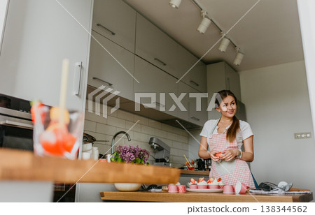 The action of making red velvet cupcakes. Woman hand piping cream cheese on cupcake. The action of making red velvet cupcakes. Woman hand piping cream cheese on cupcake. 138344562