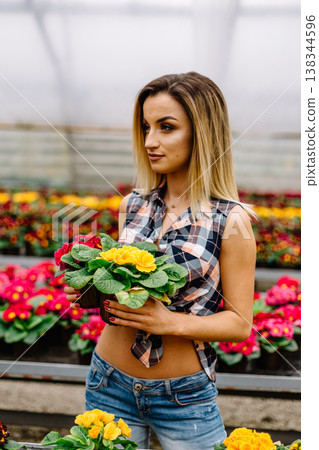 Young woman buying flowers at a garden center Young woman buying flowers at a garden center 138344596