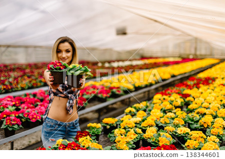 Young woman buying flowers at a garden center. Young woman buying flowers at a garden center. 138344601