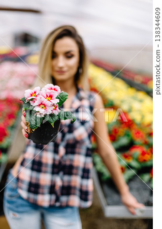 Young woman buying flowers at a garden center 138344609