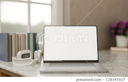 White screen laptop with books and headphones aside flower pot on marble counter table by the window White screen laptop with books and headphones aside flower pot on marble counter table by the window 138345937