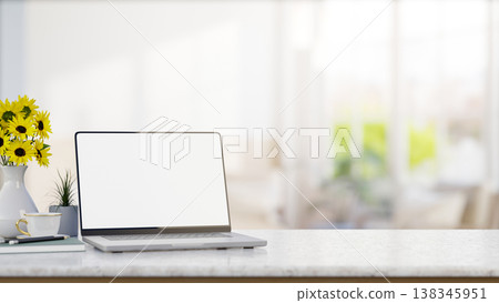 White screen laptop with coffee and book aside sunflower vase on marble counter table in bright room White screen laptop with coffee and book aside sunflower vase on marble counter table in bright room 138345951