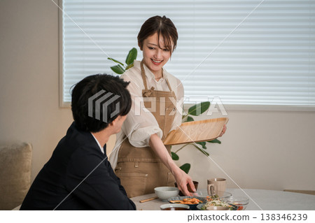 一對夫婦或一家人在餐桌上吃飯的場景(上菜、家常菜、家常飯菜、晚餐)。 一對夫婦或一家人在餐桌上吃飯的場景(上菜、家常菜、家常飯菜、晚餐)。 138346239
