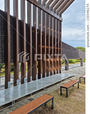 An outdoor park with wooden pillars and benches. 138346274