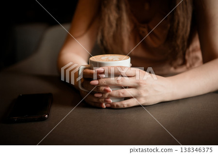 Close-up of a female hands holding a cup of coffee Close-up of a female hands holding a cup of coffee 138346375