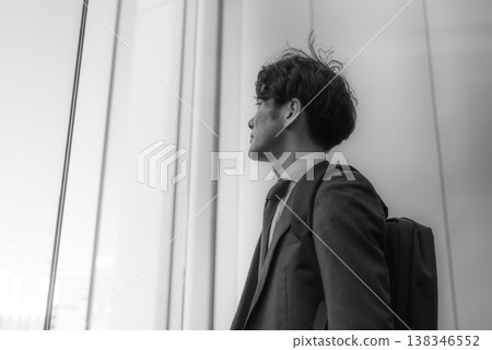 A businessman gazing at the future from a window A businessman gazing at the future from a window 138346552