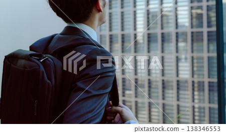 A man with a backpack on looks up out the window. A man with a backpack on looks up out the window. 138346553