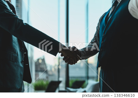 Two businessmen shaking hands in an office. 138346610