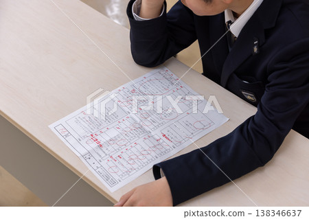 A male student holding his head in despair. 138346637
