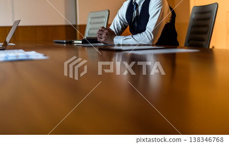 一位身著西裝的商人正在會議室等候。 138346768