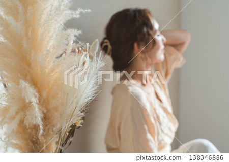 A woman and dried flowers in a living room bathed in the western sun (model, fashion, light, shadow) 138346886