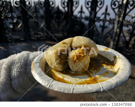 Close-up of traditional Himachali Sittu served on a paper plate, showing stuffed steamed bread with local spices, captured outdoors in natural sunlight. Close-up of traditional Himachali Sittu served on a paper plate, showing stuffed steamed bread with local spices, captured outdoors in natural sunlight. 138347098