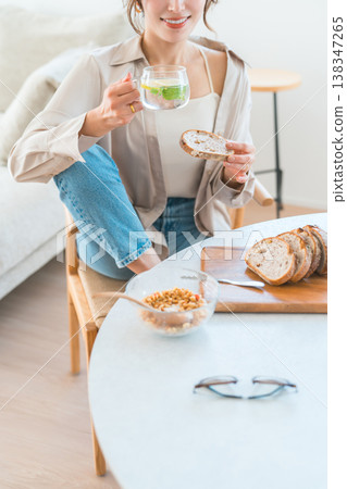 Young Asian woman having breakfast at the dining table Young Asian woman having breakfast at the dining table 138347265