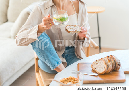 Young Asian woman having breakfast at the dining table Young Asian woman having breakfast at the dining table 138347266